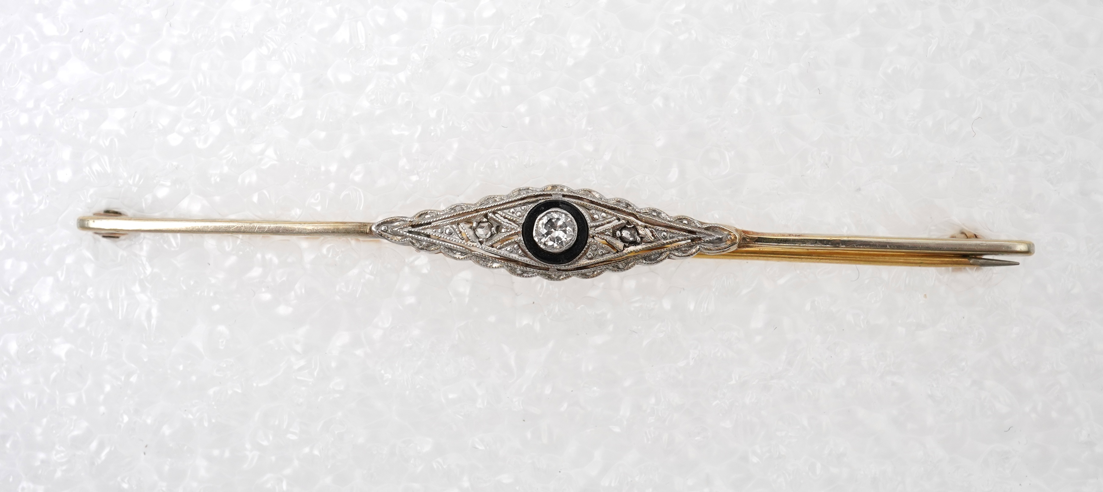A collection of jewels and accessories, comprising: an onyx and diamond bar brooch, mounted in gold; a bangle set with a circular-cut diamond weighing approximately 0.07 carats, inner circumference approximately 17cm, st